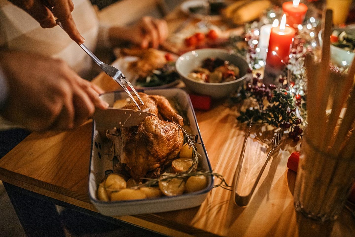 Man serving roasted chicken to his wife on the occasion of Christmas dinner celebration